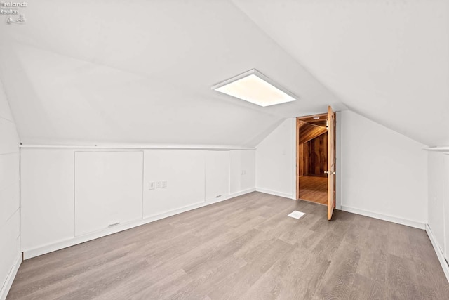 bonus room featuring light wood-style flooring and vaulted ceiling