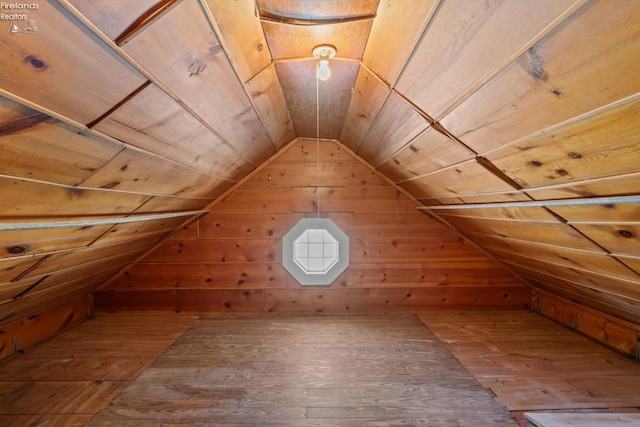 additional living space with vaulted ceiling, wood walls, wooden ceiling, and wood finished floors