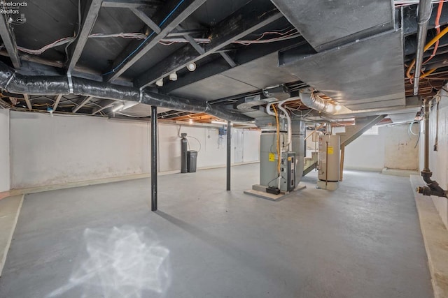 unfinished basement featuring heating unit and water heater