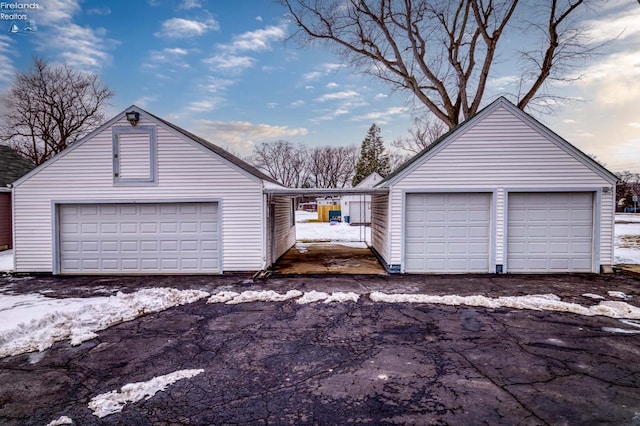 snow covered garage featuring a garage