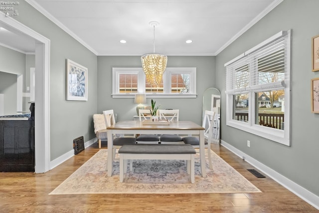 dining room with baseboards, visible vents, and crown molding