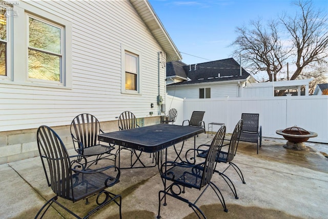 view of patio with an outdoor fire pit, outdoor dining area, and fence