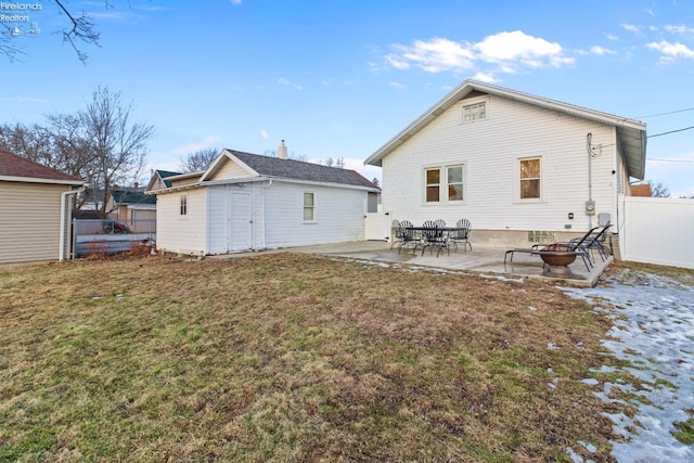 back of house with fence, an outdoor structure, a lawn, and a patio