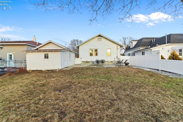 rear view of house with an outbuilding, a fenced backyard, a yard, and a patio