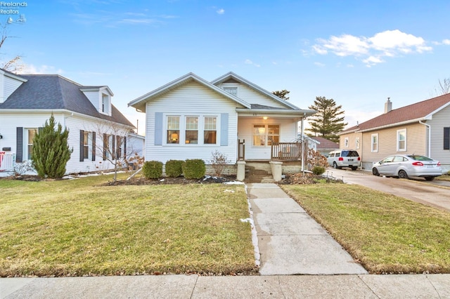 bungalow with a porch and a front lawn