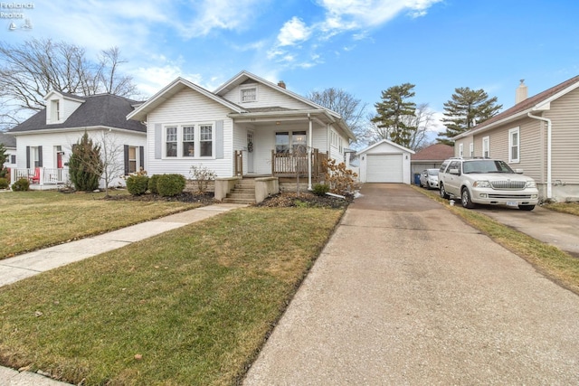 bungalow-style house with covered porch, concrete driveway, a front yard, a garage, and an outdoor structure