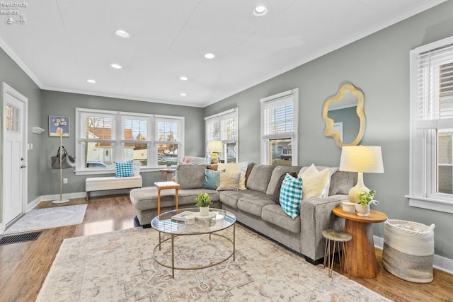 living area featuring baseboards, wood finished floors, and crown molding