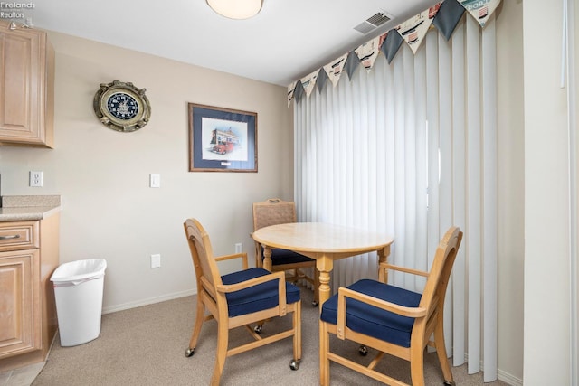 dining space featuring light carpet, baseboards, and visible vents