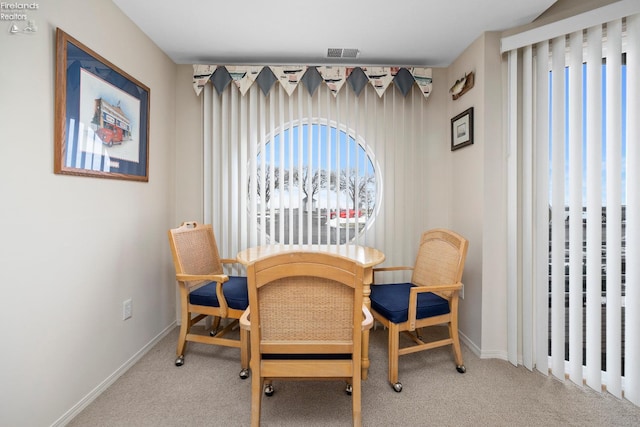 carpeted dining room featuring baseboards and visible vents