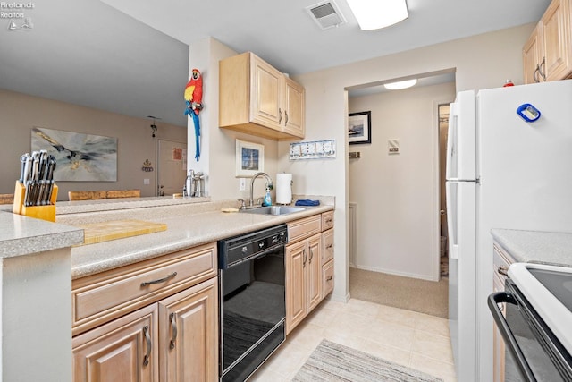 kitchen with black dishwasher, light countertops, visible vents, light brown cabinetry, and a sink