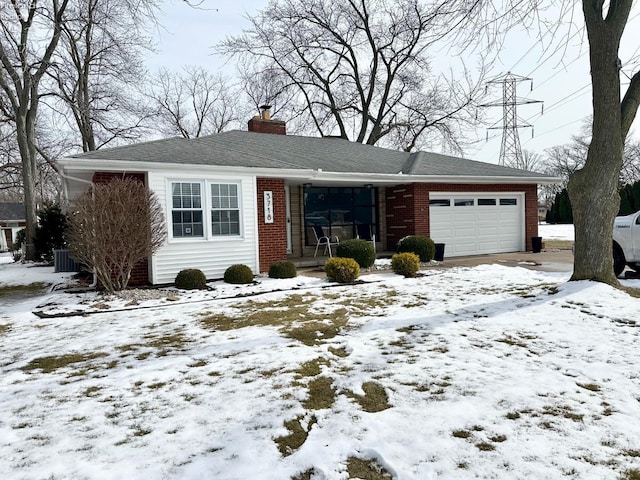 ranch-style home featuring a chimney, brick siding, central AC, and an attached garage