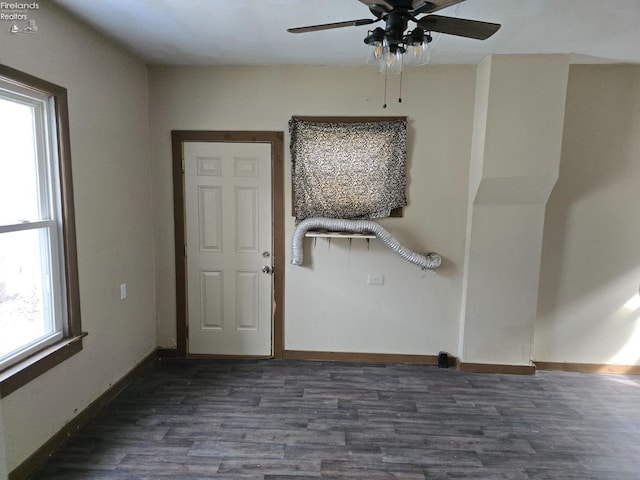 spare room featuring dark wood-style floors and baseboards