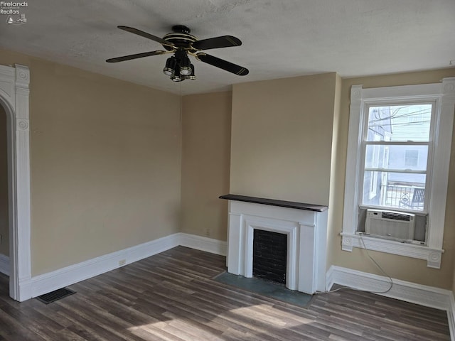 unfurnished living room featuring baseboards, visible vents, a fireplace with flush hearth, dark wood-type flooring, and cooling unit