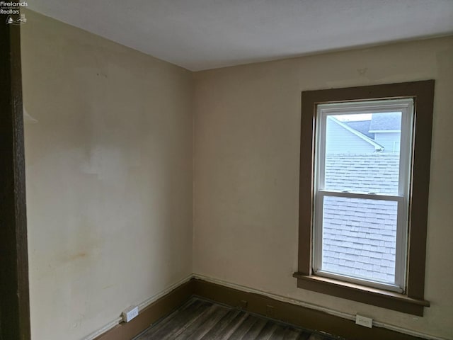 empty room featuring dark wood-style flooring and baseboards