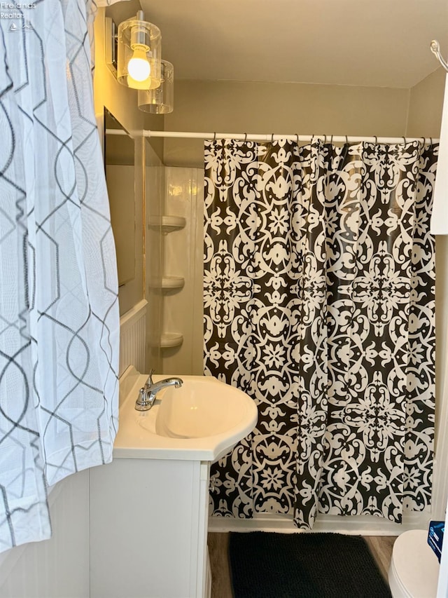 full bath featuring toilet, vanity, and a shower with curtain