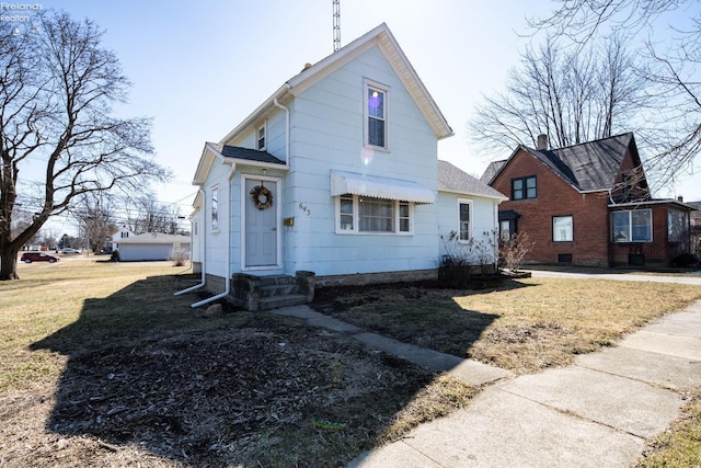 bungalow-style home with entry steps and a front yard