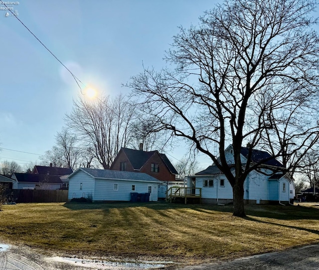 view of property exterior featuring a chimney, fence, a deck, and a yard