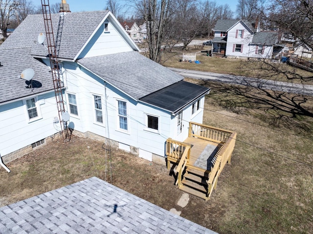 rear view of house featuring a shingled roof