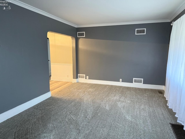 carpeted empty room featuring baseboards, visible vents, and ornamental molding