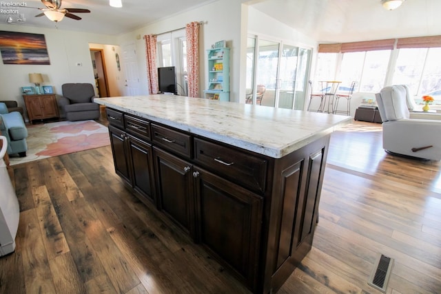 kitchen with a center island, open floor plan, and dark wood finished floors