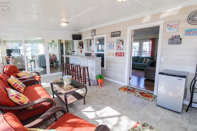 living area with a healthy amount of sunlight, baseboards, and light tile patterned floors