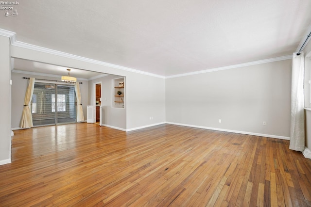 unfurnished living room featuring light wood-type flooring, crown molding, and baseboards