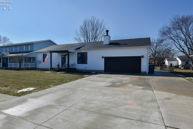 view of front facade featuring a garage, driveway, roof with shingles, a chimney, and a front yard