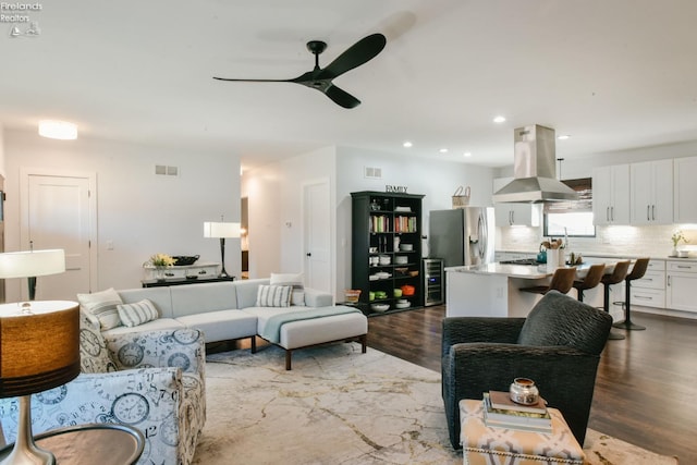 living room featuring a ceiling fan, recessed lighting, visible vents, and wood finished floors