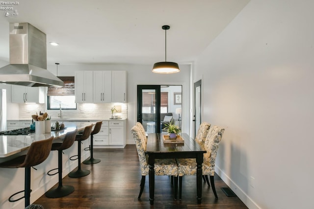 dining space with baseboards, visible vents, and dark wood finished floors