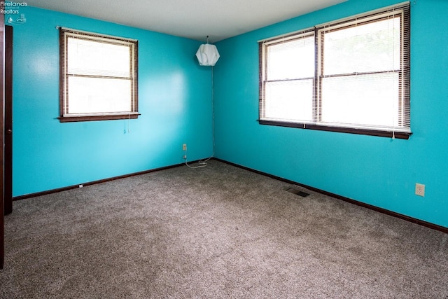 carpeted empty room with baseboards and visible vents