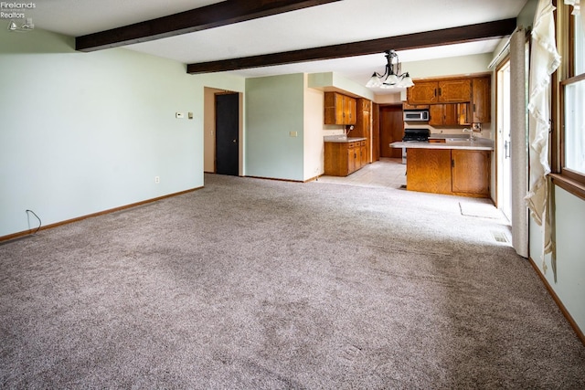 unfurnished living room with a chandelier, beam ceiling, light colored carpet, and baseboards