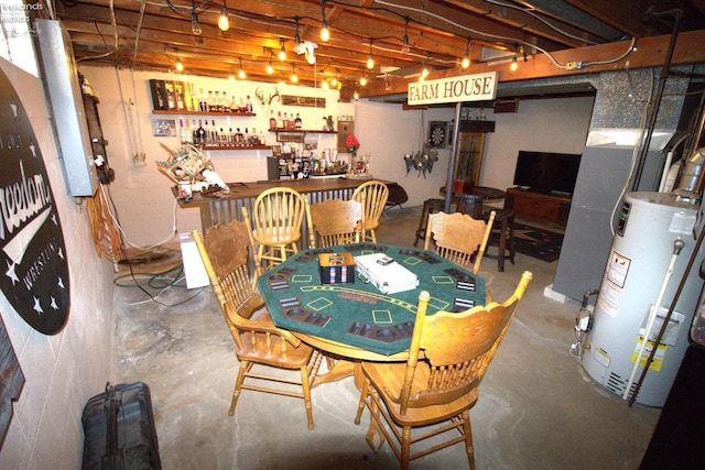 dining room featuring gas water heater, a dry bar, and unfinished concrete floors