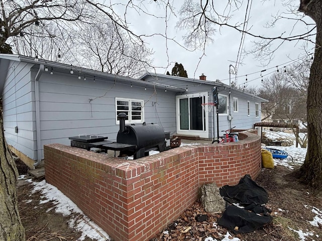 back of property featuring a chimney and heating fuel