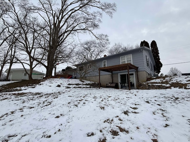 snow covered property featuring a garage and a chimney