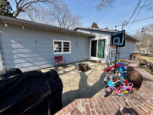 back of property with a fire pit and a patio area