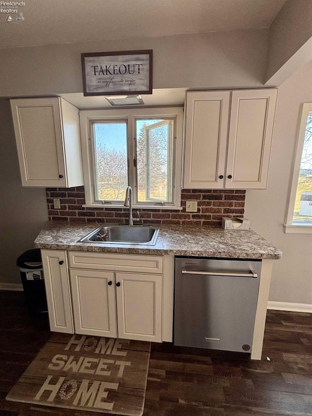 kitchen with dark wood finished floors, a sink, white cabinets, dishwasher, and backsplash