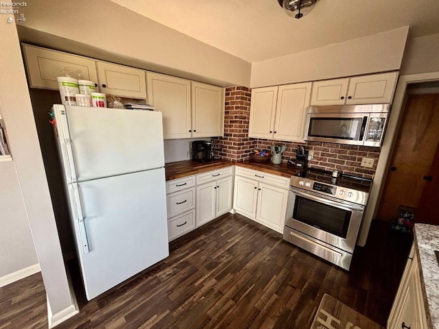 kitchen featuring wood counters, appliances with stainless steel finishes, white cabinetry, and dark wood-type flooring