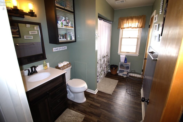 bathroom with vanity, a shower with shower curtain, toilet, and wood finished floors