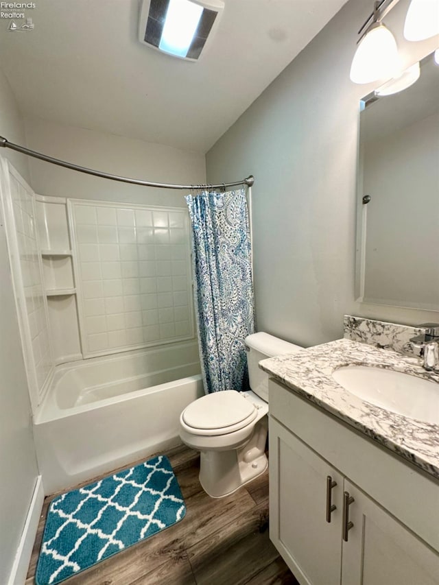 bathroom featuring shower / bath combo, toilet, wood finished floors, vaulted ceiling, and vanity