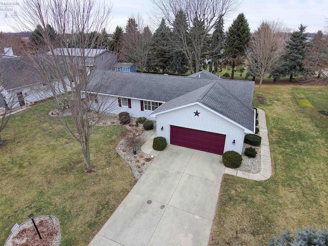 view of front of property featuring a garage, a front yard, a shingled roof, and driveway