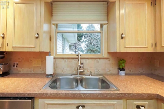 kitchen featuring light brown cabinets, a sink, light countertops, stainless steel dishwasher, and decorative backsplash