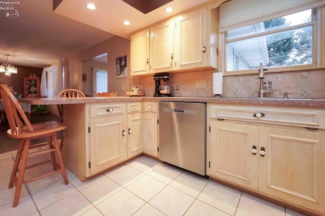 kitchen with a sink, tasteful backsplash, a peninsula, and dishwasher