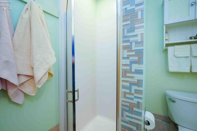 bathroom featuring a shower stall and toilet