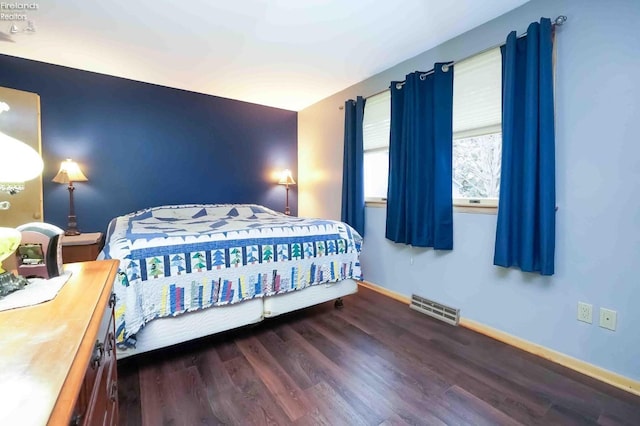 bedroom featuring visible vents, baseboards, and wood finished floors