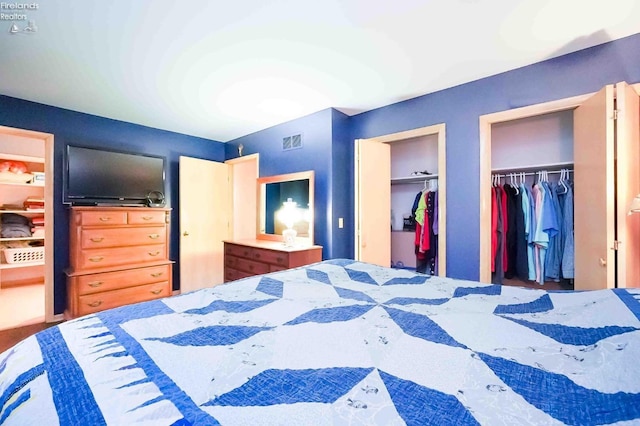 bedroom with visible vents and multiple closets