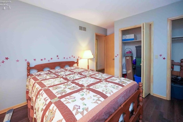 bedroom with wood finished floors, visible vents, and baseboards