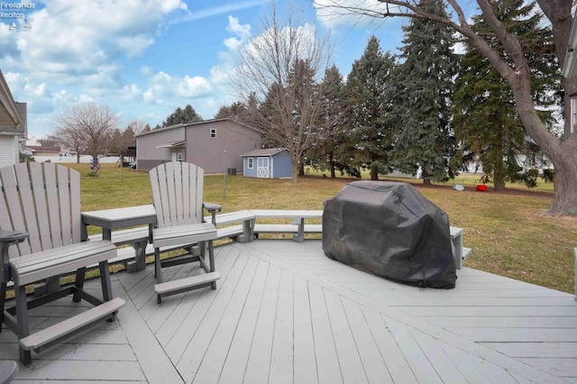 wooden terrace featuring a storage shed, grilling area, a lawn, and an outdoor structure