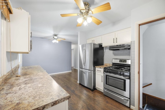 kitchen with under cabinet range hood, white cabinetry, appliances with stainless steel finishes, backsplash, and dark wood finished floors