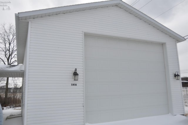 snow covered garage with a garage