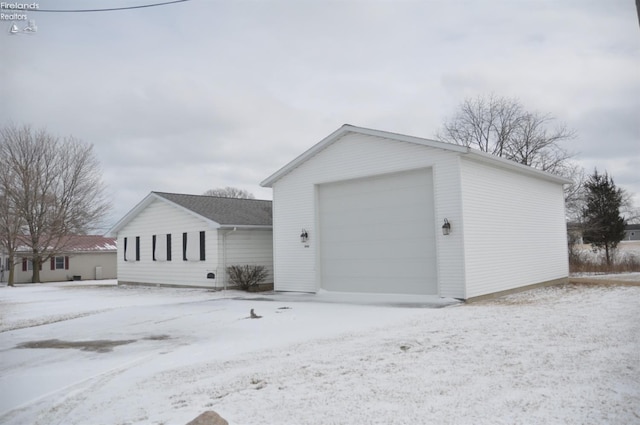 snow covered garage featuring a garage